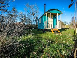 Dragonfly Shepherds Hut - lit by solar lights for a magical evening under the stars.