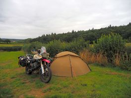 At the camping site, a motorcycle and a tent.
