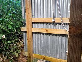 Outdoor shower area with warm water, locking doors, shelves and hooks for practicality.