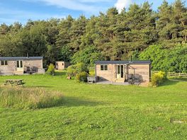 View of two of the three huts from the wildflower meadow