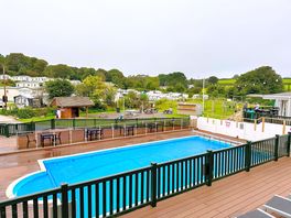 Pool area with sun beds on the decking.