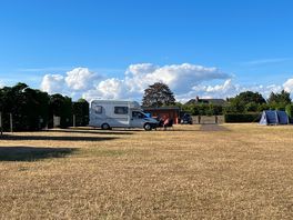 Grass pitches far enough apart with some hedges providing privacy from from access road in the site