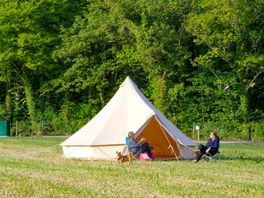 Guests sit outside of the bell tent