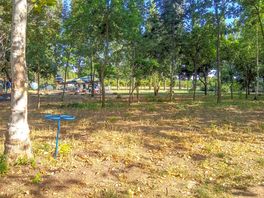 Shaded grass and earth pitch with view of the aeroplane
