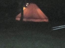The bell tent all lit up at night.