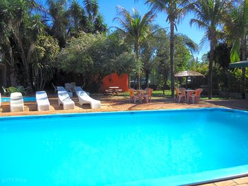 Swimming pool equipped with sun beds, tables and parasols