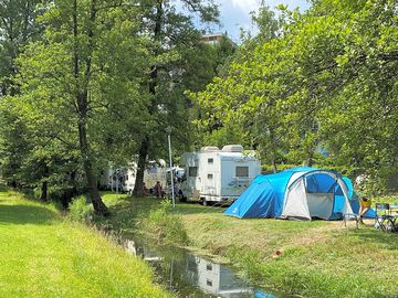 Grass pitches by a stream