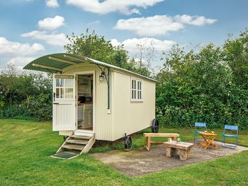 Outside of the shepherd's hut with the seating area and patio