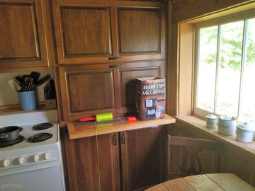 Kitchen and stove with table and window.