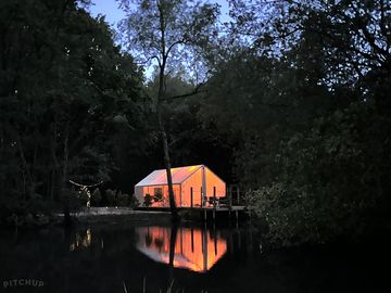 Waterfront glamping tent at night