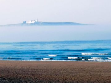 Farne islands rising out of the sea mist.