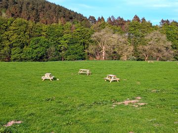 Camping meadow backed by wooded hills