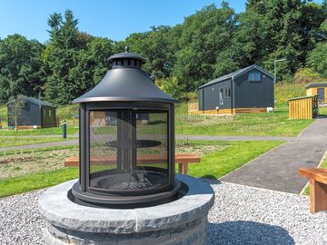 Communal fire pit with glamping cabins in the background