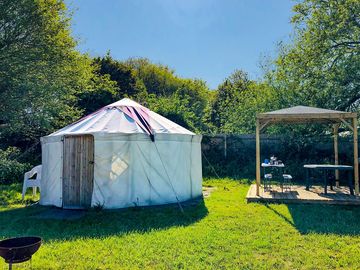 The outside of the yurt and the wooden gazebo for use to cook under if raining