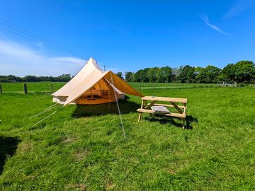 Furnished bell tent and picnic bench