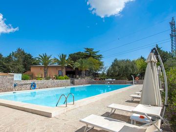 Swimming pool with sun loungers and umbrellas