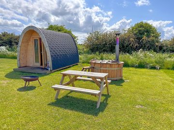 Our camping pod setup with hot tun, bench and fire pit