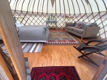 Yurt interior with bed, sofa and comfy seating