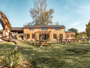 The cider garden/sculpture garden with the tasting room, tap room and farm shop behind