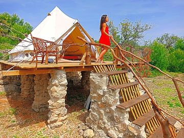 Bell tent raised on pillars