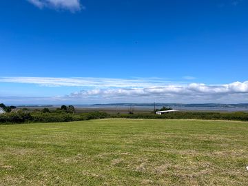 Non-electric grass pitches with estuary views