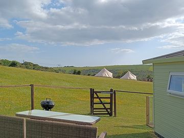 General site photo taken from the garden of barn owl cabin showing the view and the bell tents