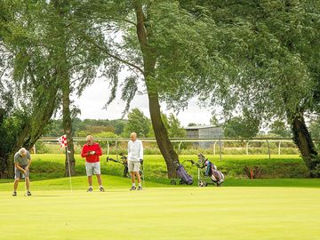 Golfers with the racecourse in the background