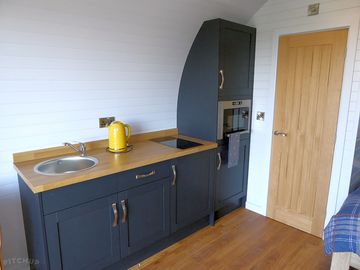 Kitchen with a sink, microwave, two-ring induction hob and large fridge with a freezer compartment