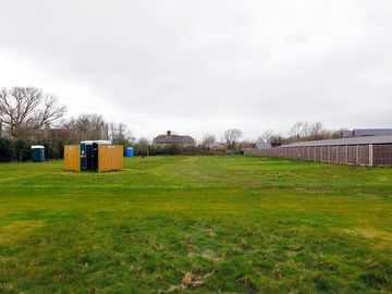 South field - electric pitches and central wooden enclosure of communual chemical toilets