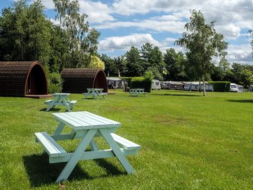 Exterior of glamping pods with picnic bench seating