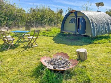 Exterior of the Landpod with firepit, table and chairs