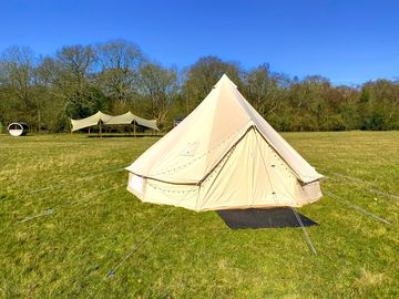 Bell tent with communal stretch tent and sauna in the background
