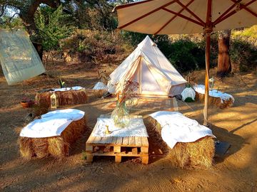 Bell tent pitch with table and bales as chairs