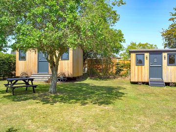 Shepherd's huts in neatly kept gardens