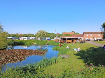 A view of the fishing pond, Waterside pitches and the bar. (added by manager 21 May 2024)