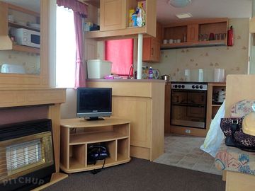 Living room and fully-equipped kitchen corner