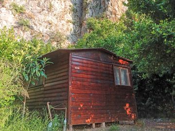 Wooden bungalow with a dramatic cliff backdrop