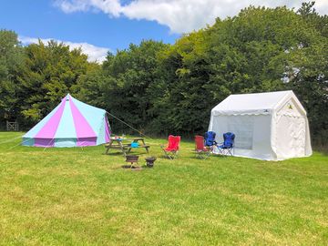 Furnished bell tent with kitchen tent and outdoor furniture.