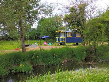 The blue gypsy caravan by the river