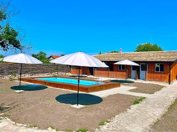 Blick auf die ferienzimmer mit pool und sonnenschirmen.