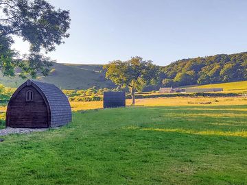 The camping field, with two of the pods, looking back uphill