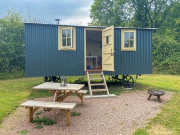 Outdoor seating and fire pit to relax outside the Shepherd's hut