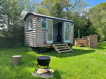 Wood-fired hot tub, screened by hazel hurdles. Fire pit and seating