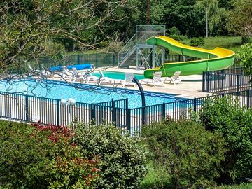 Pool area with slides and deck chairs