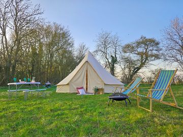 Bell tent with campfire and outdoor seating