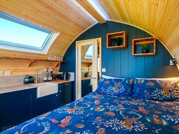 King size bed featured in picture along with a kitchenette including stove,oven kettle and equipment