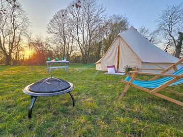 Bell tent with campfire and outdoor seating