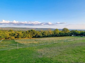 View from the hilltop of the 'Top Field' camping area, looking down over the goat paddock