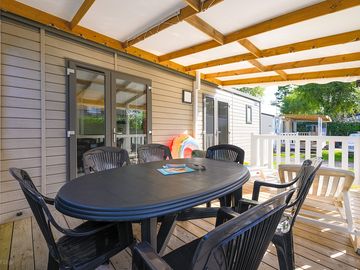 Terrasse semi-couverte idéale pour repas et détente en plein air.