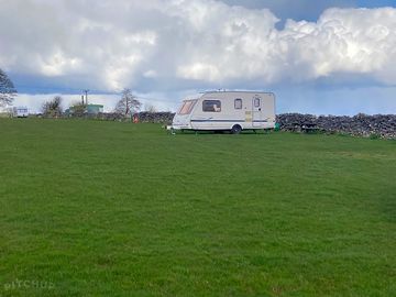 Caravan and view of one of the pitches on the site